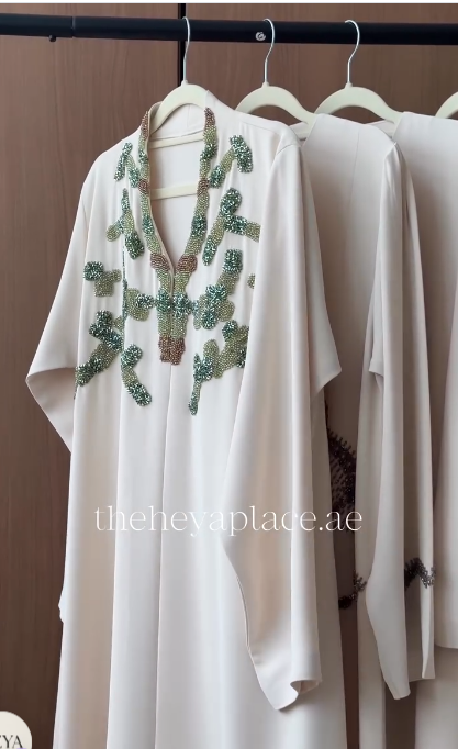 Emerald Vine Abaya in ivory with green and champagne beaded botanical embellishments and flowing sleeves.