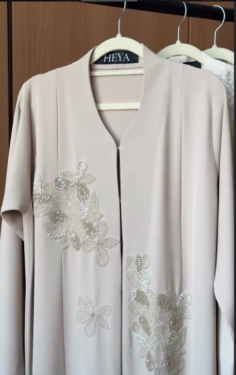 HEYA Crystal Petals Abaya in soft beige with hand-beaded crystal floral embellishments and elegant flowing silhouette.