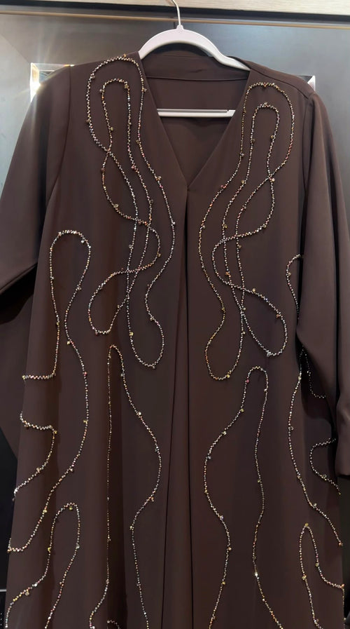 Woman wearing the Chocolate Cascade Abaya in elegant modest design with a flowing silhouette.