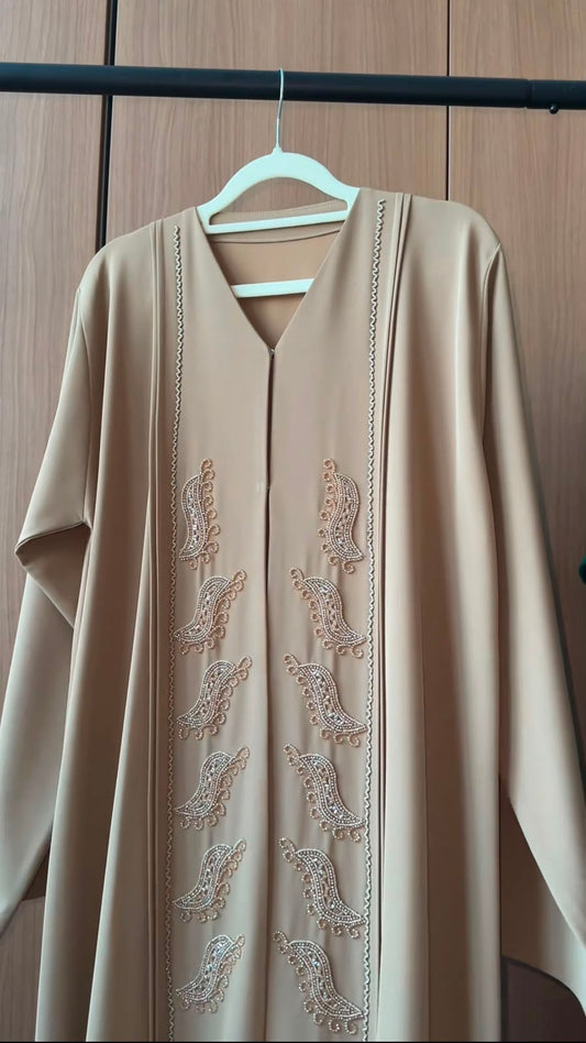 Desert Pearl Abaya in sand beige featuring handcrafted pearl paisley embellishments with a graceful flowing silhouette.