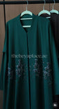 Emerald Noir Abaya in deep emerald green with shimmering floral beadwork and an elegant flowing silhouette.