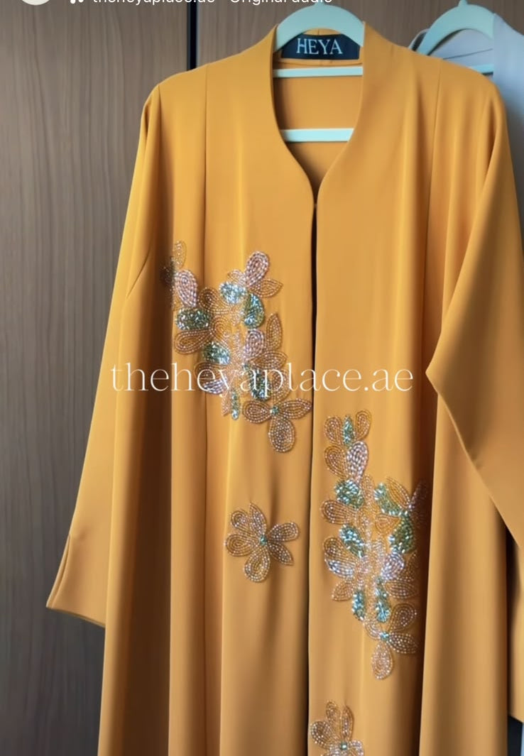 Golden Bloom Abaya in a luxurious golden-yellow shade featuring hand-beaded floral embroidery with pearl, crystal, and soft mint accents.