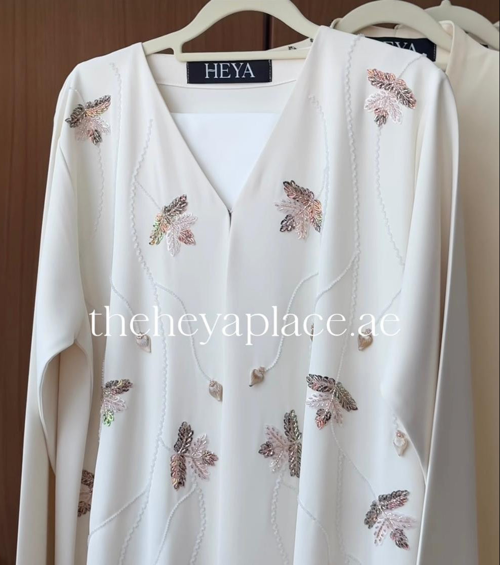 Ivory Leaf Elegance Abaya featuring delicate leaf bead embellishments and a graceful flowing silhouette in premium fabric.