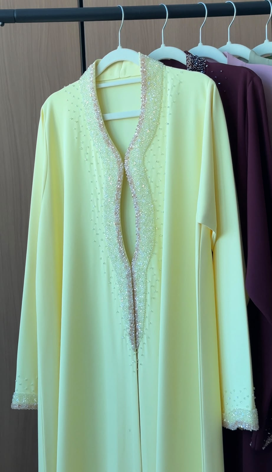 Lemon Pearl Abaya in a soft pastel lemon shade featuring pearl and crystal embellishments on the neckline and cuffs with an elegant flowing silhouette.