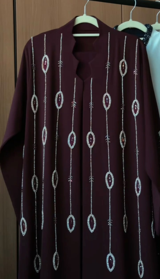 Royal Garnet Abaya in deep garnet burgundy featuring cascading vertical crystal beadwork and an elegant flowing silhouette.