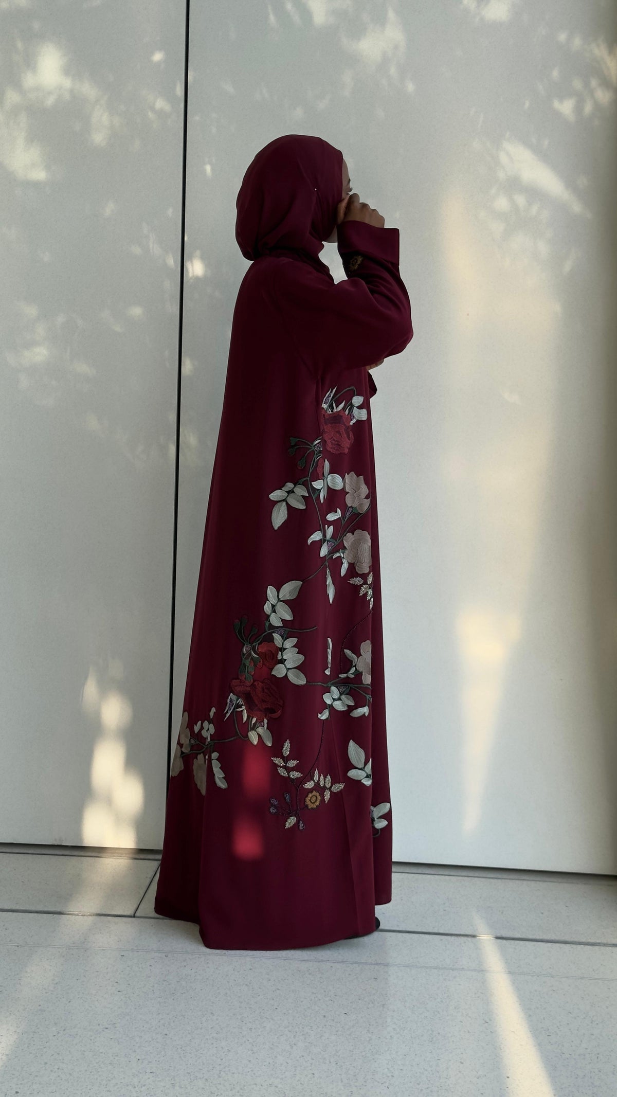 Side view of Wardah Burgundy Abaya with delicate ivory and red floral embroidery.